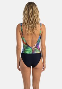 Badedragt i ét stykke med et farverigt tropisk bladmønster på overdelen, navyblåt bundstykke og et dybt V-rygdesign.