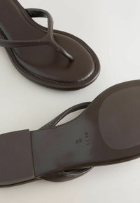 Sandales en cuir marron avec semelles plates, montrant une vue de dessus de l'avant et une vue de dessous de la semelle estampillée avec la taille et la marque.