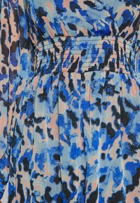 Virallinen mekko, jossa on sininen ja vaaleanpunainen abstrakti kuvio, röyhelövyötärö ja pitkät hihat, valmistettu kevyestä kankaasta.