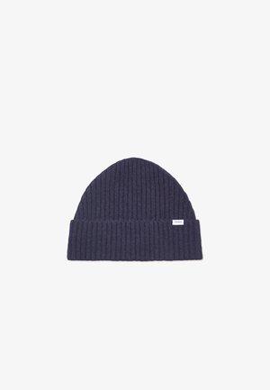 Marineblaues, geripptes Strickmütze mit umgeschlagenem Bund und kleinem Markenlabel an der Seite. Weiche Textur, zylindrische Form und vielseitig für kaltes Wetter.