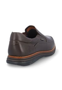 Zapato marrón de cuero sin cordones con punta redondeada y paneles elásticos laterales. Costuras en contraste y una suela estratificada con fondo de goma.