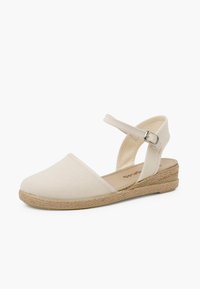 Beige canvas espadrille met een ronde neus, enkelbandje en een geweven jute wedge hak. Glad textuur en minimalistisch ontwerp.