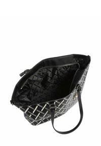 Bolso tote negro con patrón geométrico blanco, material sintético, dos asas resistentes y un bolsillo interior con cremallera. Forro texturizado visible.