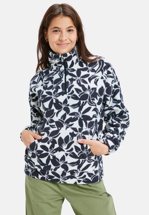 Pull en polaire avec col montant, motif botanique bleu marine et blanc, fermeture éclair à l'avant, manches longues et poches latérales. Texture douce et coupe décontractée.