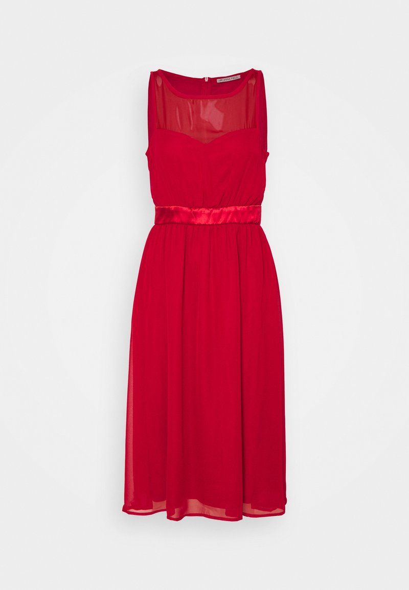 Robe midi rouge sans manches avec encolure transparente et ceinture brillante, suspendue sur fond blanc.