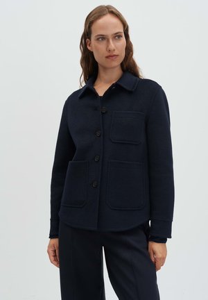 Navy blue fleece jacket with a collared neckline, front buttons, and two patch pockets. Features a smooth texture and a relaxed fit.
