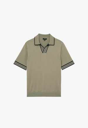 Tricou polo cu mâneci scurte, verde măsliniu, cu guler și margini ale mânecilor cu dungi alb-negru, așezat pe o suprafață albă.