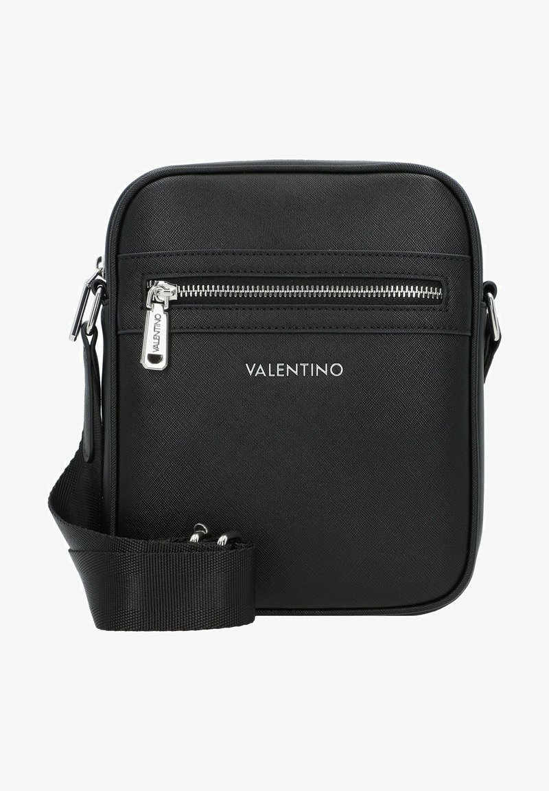 Mustmust ristmikot, mis on valmistatud tekstuuritud sünteetilisest materjalist, esiküljel on lukuga tasku, hõbedased detailid ja reguleeritav rihm.