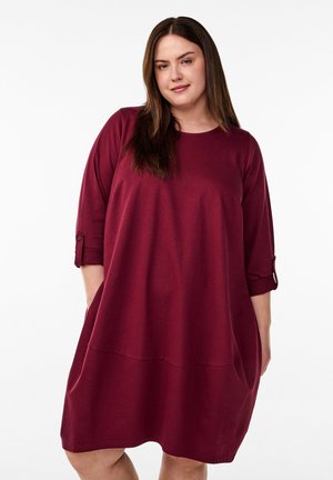 Bordeauxfarbenes Baumwollkleid mit lockerer Passform, rundem Ausschnitt, Dreiviertelärmeln und Seitentaschen. Mit geknöpften Ärmelabschlüssen und einer glatten Textur.