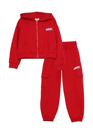 Set di felpa rossa con cappuccio e pantaloni tuta, realizzato in tessuto morbido. La felpa presenta una zip frontale, tasche e un logo stampato. I pantaloni hanno un cinturino elastico e tasche cargo.