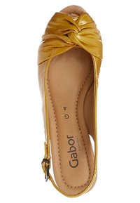 Chaussure à bout ouvert en cuir verni jaune avec un détail en nœud torsadé à l'avant, semelle intérieure rembourrée et bride de cheville avec fermeture à boucle.