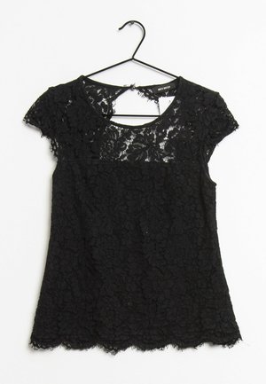 Černý krajkový top s krátkými rukávy a květinovým vzorem, kulatým výstřihem a vroubkovaným lemem, zavěšený na černém ramínku na bílém pozadí.
