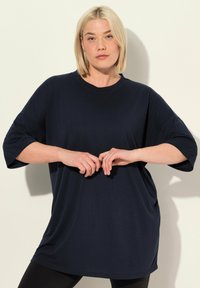 T-shirt oversized di un blu navy scuro realizzato in tessuto morbido, con scollatura rotonda e maniche corte, dal taglio comodo.