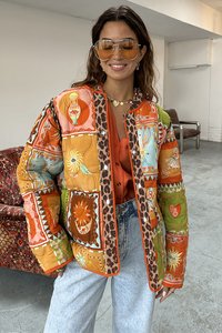 Gequilted jack met levendige oranje en groene patronen, accenten van luipaardprint, drukknoopsluitingen en een boxy silhouette.