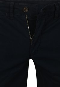 Navyblauwe broek met ritssluiting, knoopsluiting en riemlussen. Gemaakt van een soepele stof met subtiele stikseldetails.