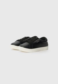 Sorte lær sneakers med rund tå, hvit gummisåle og flate svarte lisser. Har et teksturert panel og minimale accenter.