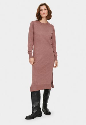 Long-sleeve, dusty rose knit dress with side slit and ribbed hem, paired with knee-high black leather boots. Simple, fitted design.
