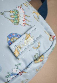 Ljusblå tygväska med lekfulla illustrerade mönster, inklusive tårtor och dekorationer. Guld "Cath Kidston"-logotyp på ett sytt etikett.
