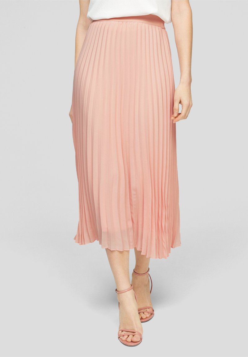 Skládaná midi sukně z měkké růžové látky, s přiléhavým pasem a volným střihem. Kombinováno s páskovými tělovými podpatky.