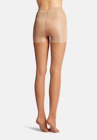 Beige shorts lavet af gennemsigtigt, strækbart materiale med en bred elastisk talje og en glat overflade, designet til at sidde tæt.