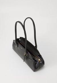 Schwarze Lederhandtasche mit zwei langen Tragegriffen, einem Reißverschluss und goldenen Hardware-Akzenten; glatte Textur und strukturiertes Design.