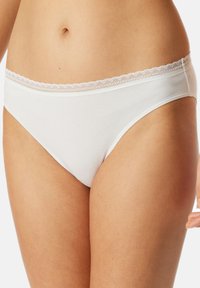 Witte katoenen bikini slipjes met een delicate kantafwerking bij de tailleband. Soepele textuur, aansluitende vorm en minimale bedekking.