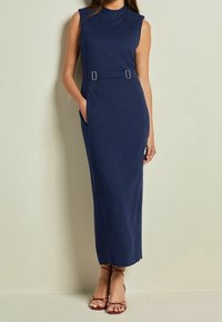 Robe sans manches bleu marine avec un col montant, dotée de poches latérales et d'une ceinture avec des détails en métal argenté, confectionnée dans un tissu lisse.