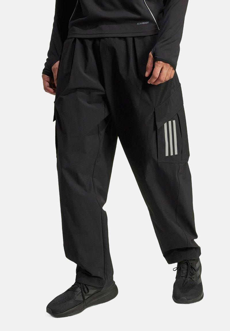 Black cargo pants with a loose fit, featuring side pockets, a textured fabric, and three vertical stripes on the left leg. Pairing with black shoes.