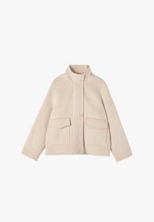 Jasny beżowy wełniany płaszcz z kołnierzem typu stójka, zapięciem na guziki z przodu oraz dwoma dużymi kieszeniami z patkami na przodzie.