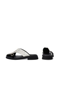 Flache Riemchensandalen mit einem silbernen Glitzerband und schwarzem Boden. Mit einer verstellbaren Schnalle, aus synthetischen Materialien gefertigt.