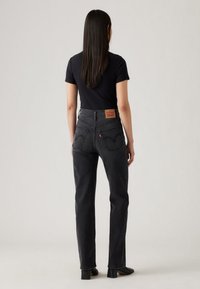 Μαύροι τζιν με ψηλή μέση και ίσια γραμμή, κατασκευασμένοι από denim, με κλασικό σχέδιο πέντε τσεπών, αντίθετη ραφή και δερμάτινο ταμπελάκι με λογότυπο στο πίσω μέρος.