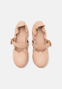 Ροζ ψεύτικες δερμάτινες μπαλαρίνες με ρυάκια στις άκρες και χρυσό λουρί. Μαλακή υφή, στρογγυλή μύτη, απλός σχεδιασμός και ελάχιστη σήμανση.