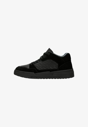 Zwarte sportieve schoenen met een combinatie van suede en glad leer, een gestructureerd zijpaneel, vetersluiting en een dikke rubberen zool.