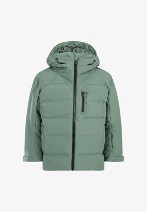 Grüne Steppjacke mit Reißverschluss vorne, Seitentaschen und Kapuze. Kombiniert mit passenden, locker sitzenden Hosen und schwarzen Stiefeln. Blaue Skibrille auf dem Kopf.