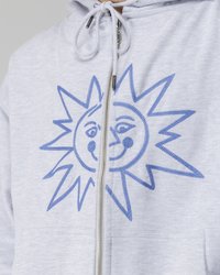 Hellgrauer Hoodie mit einem blauen, gestickten Sonnendesign auf der Vorderseite. Er verfügt über einen Reißverschluss und eine Kapuze mit Kordelzug.