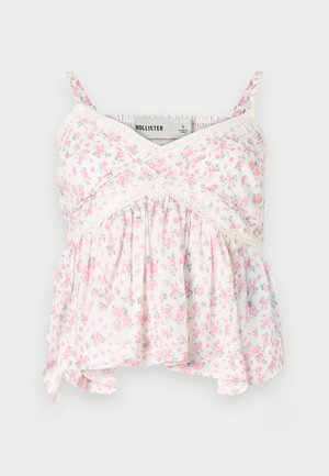 Floralna majica bez rukava s bijelom podlogom i ružičastim i zelenim cvjetovima, čipkastim detaljima, uskim korzetom i labavom, lepršavom donjom ivicom.