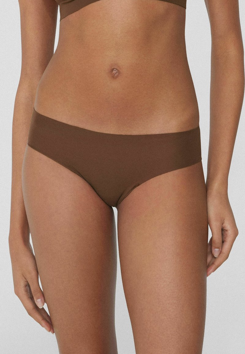 Brązowe bikini z bawełny o gładkiej, miękkiej teksturze i niskim stanie. Bezszwowe krawędzie zapewniające wygodne dopasowanie.