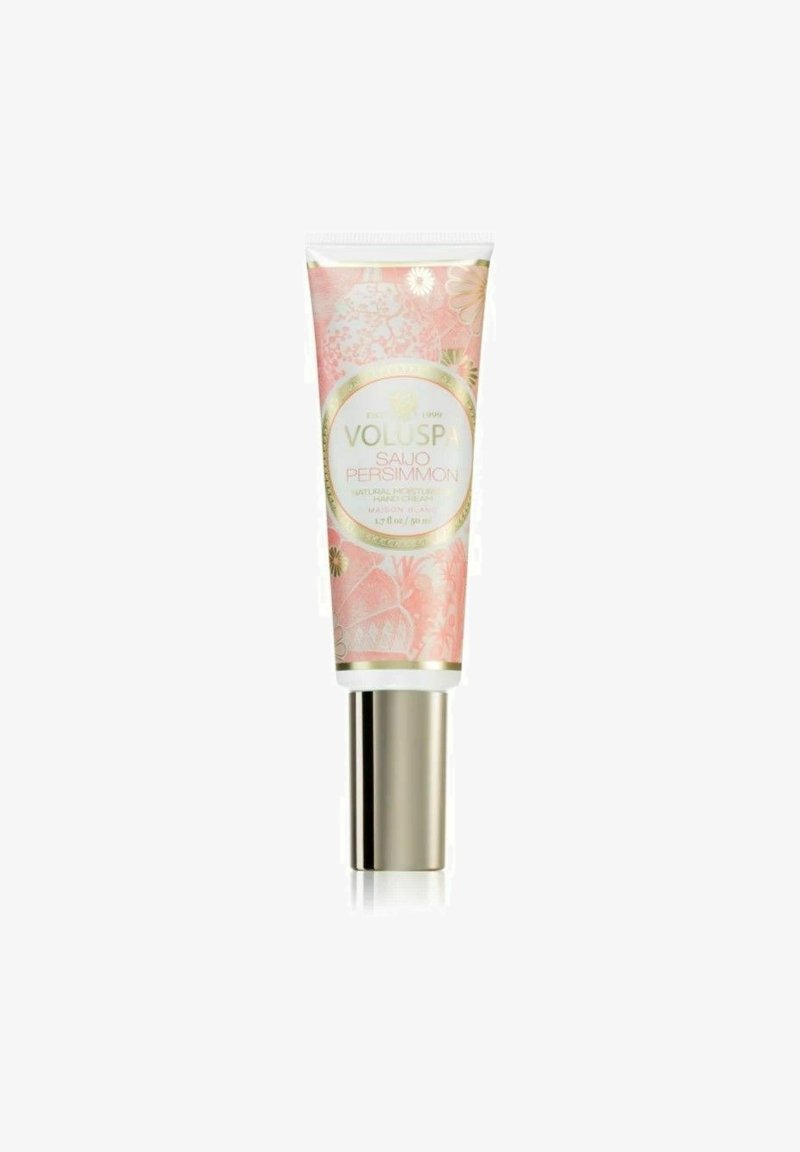 Rosa tube af Voluspa håndcreme med blomsterdesign og gyldne detaljer. Etiketten læser "Saijo Persimmon, 1,7 oz." Glat tekstur.