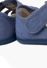 Modré látkové boty s jemnou texturou, uzavřená špička a nastavitelný suchý zip. Disponují polstrovaným interiérem pro pohodlí.