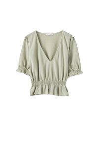 Blouse à col en V de couleur vert clair, avec des manches courtes bouffantes et une taille smockée. Tissu texturé avec des rayures subtiles et un détail de volant à l'ourlet.