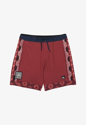 Borstsaberen in kastanjebruin met een marineblauwe tailleband, zijpanelen met zon- en golfpatronen, en een zoom met bloemmotief, voorzien van twee merklogo's.