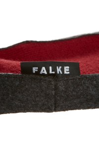 Fekete filckalap piros béléssel, amelyen egy fekete címke található, fehérrel „FALKE” felirattal. A belső része sima és textúrált.