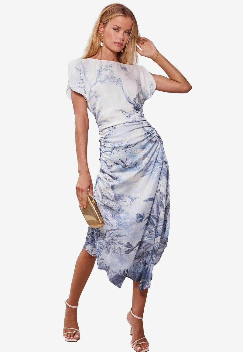 Abito a stampa floreale in azzurro chiaro e bianco, caratterizzato da un corpetto drappeggiato, vita cintrata e orlo fluente; abbinato a una pochette dorata.