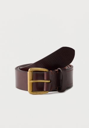 Στριμμένη ζώνη από σκούρο καφέ δέρμα με αγκράφα από ορείχαλκο, χαραγμένη με τη λέξη "POLO" σε λευκό φόντο.