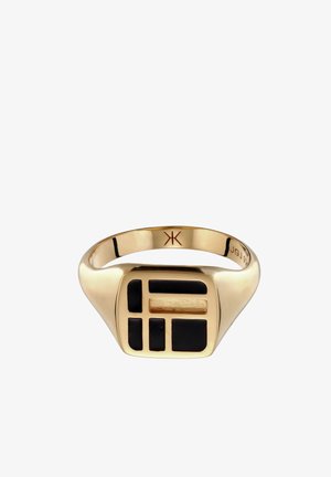 Gouden zegelring met zwarte geometrische emaille vormen op het vierkante gezicht en een gegraveerd symbool binnenin de band.