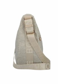 Beige, textuur tas met een gebogen vorm, voorzien van een brede beige schouderriem. Inclusief een metalen hardware detail en een subtiel patroon op het oppervlak.