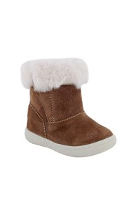 Stivaletto alla caviglia in camoscio marrone con polsino in ecopelliccia bianca, punta arrotondata e suola in gomma testurizzata; presenta cuciture a contrasto per un dettaglio in più.