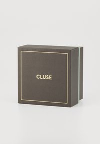Black textured gift box with gold trim and "CLUSE" logo on the front; features a mint green accent on the side.