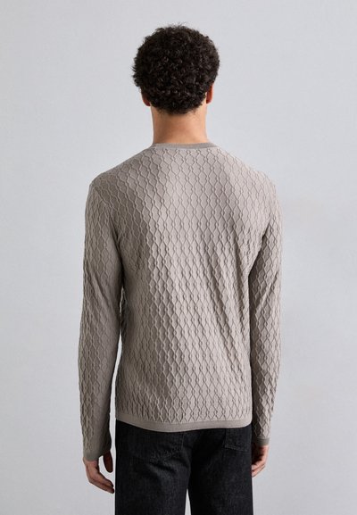 Bežs adīts džemperis ar teksturētu dimanta rakstu, garām piedurknēm, apaļu apkakli un ribotu piedurkņu un apakšmalu. Vienkāršs aizmugures skats.