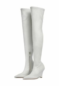 Botas blancas por encima de la rodilla hechas de cuero suave, con punta afilada, tacón en cuña y cremallera lateral para ponerlas y quitarlas fácilmente.